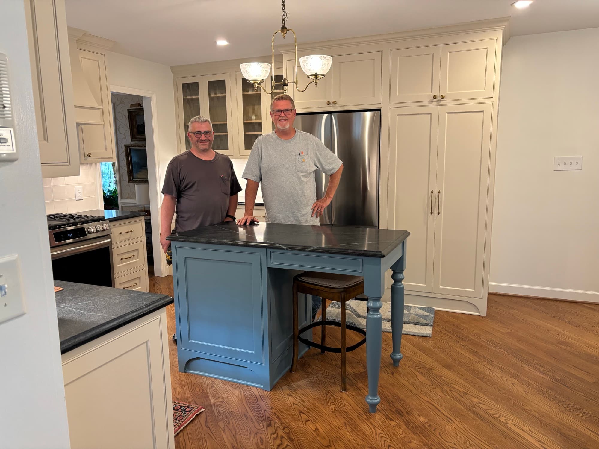 Jim Cooper and his crew at the island of a finished custom kitchen