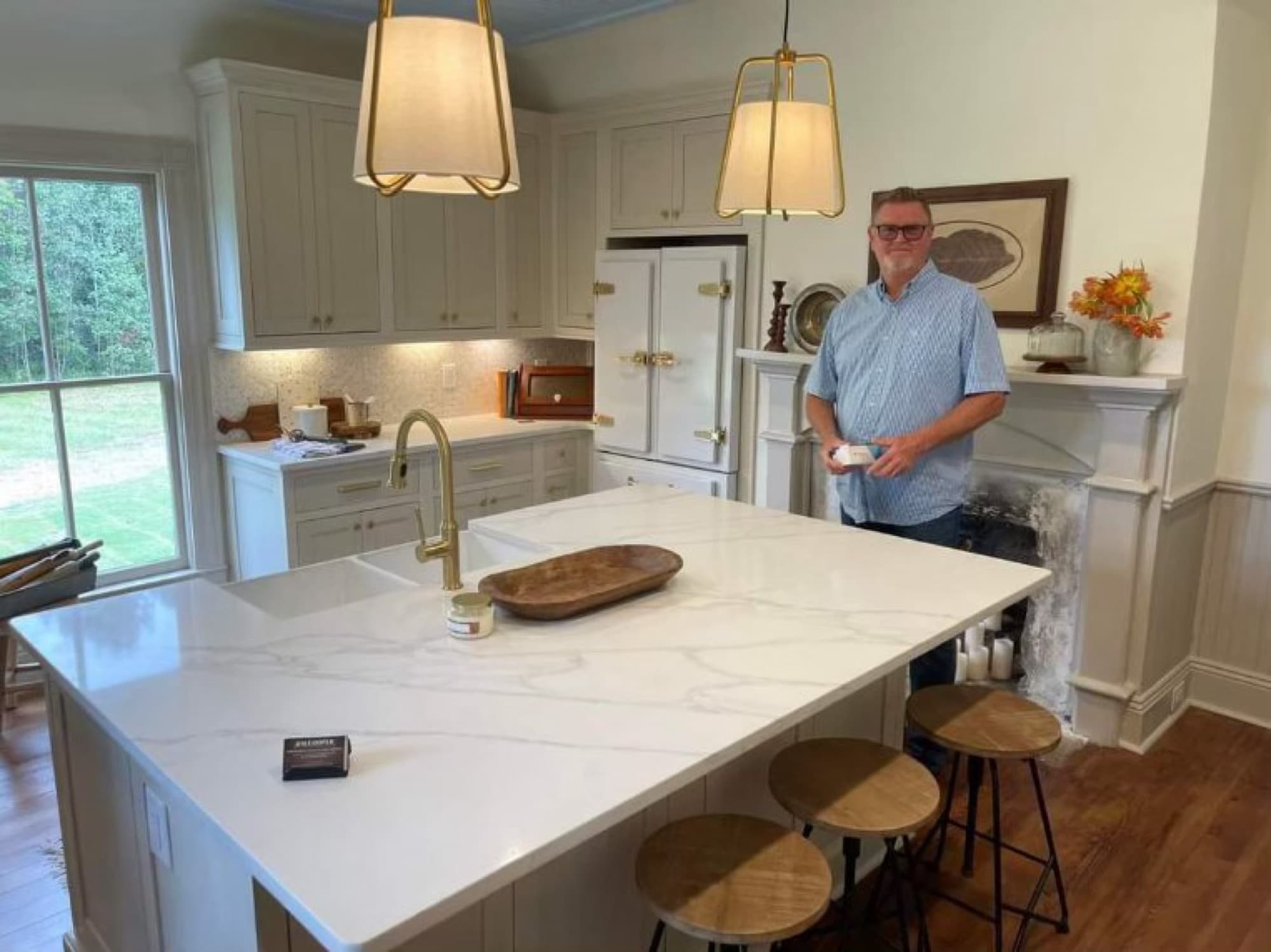 Jim Cooper in the finished Victorian kitchen, beside the inset cabinetry and marble island he built