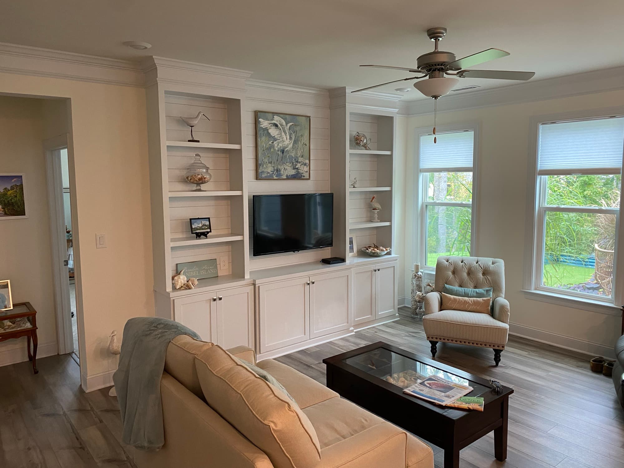 Youngsville living room with a built-in entertainment wall, shiplap backing, and display shelving by Jim Cooper Cabinetry